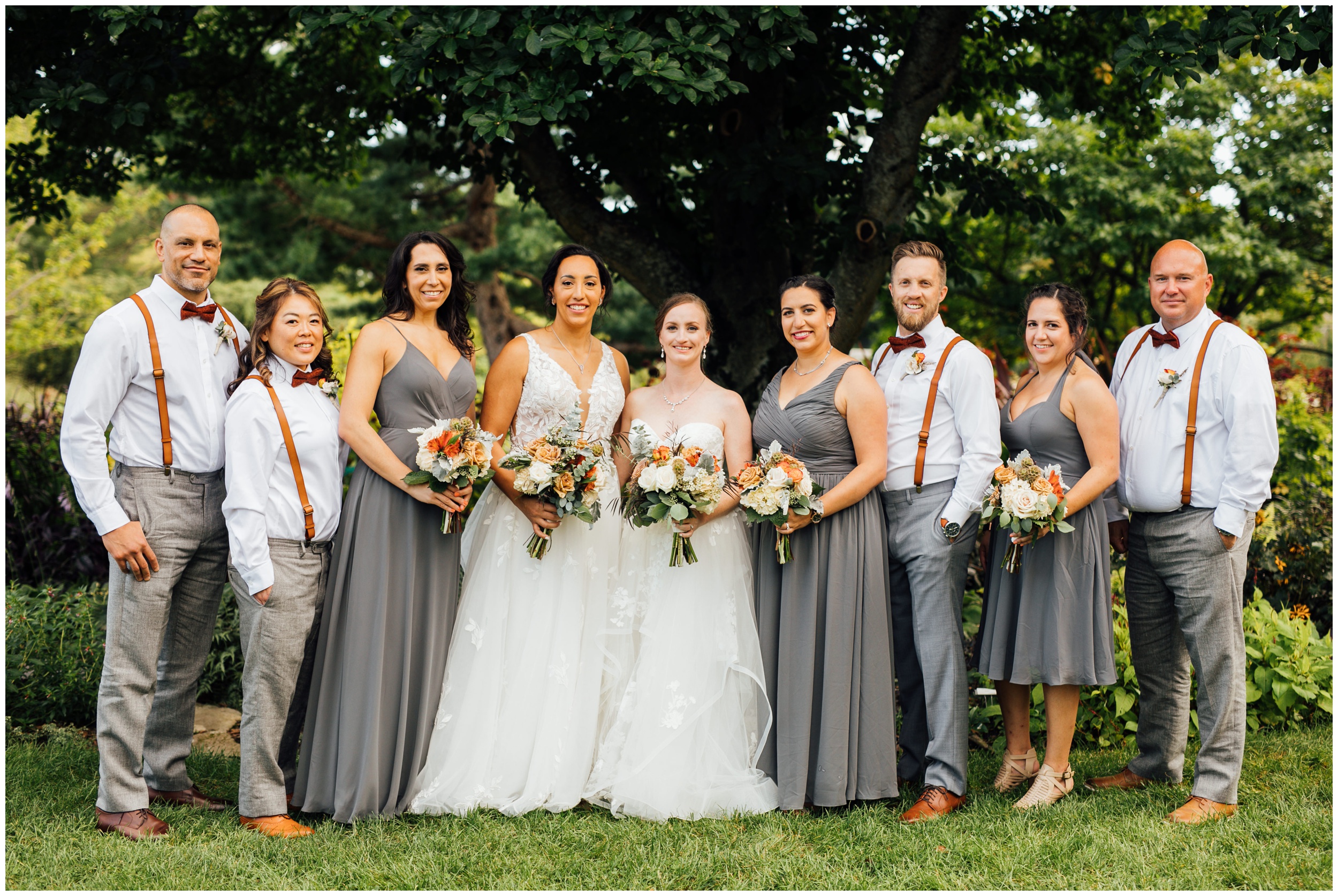 Wedding party portrait with two brides and bridesmaids at New England Botanic Garden at Tower Hill in Massachusetts